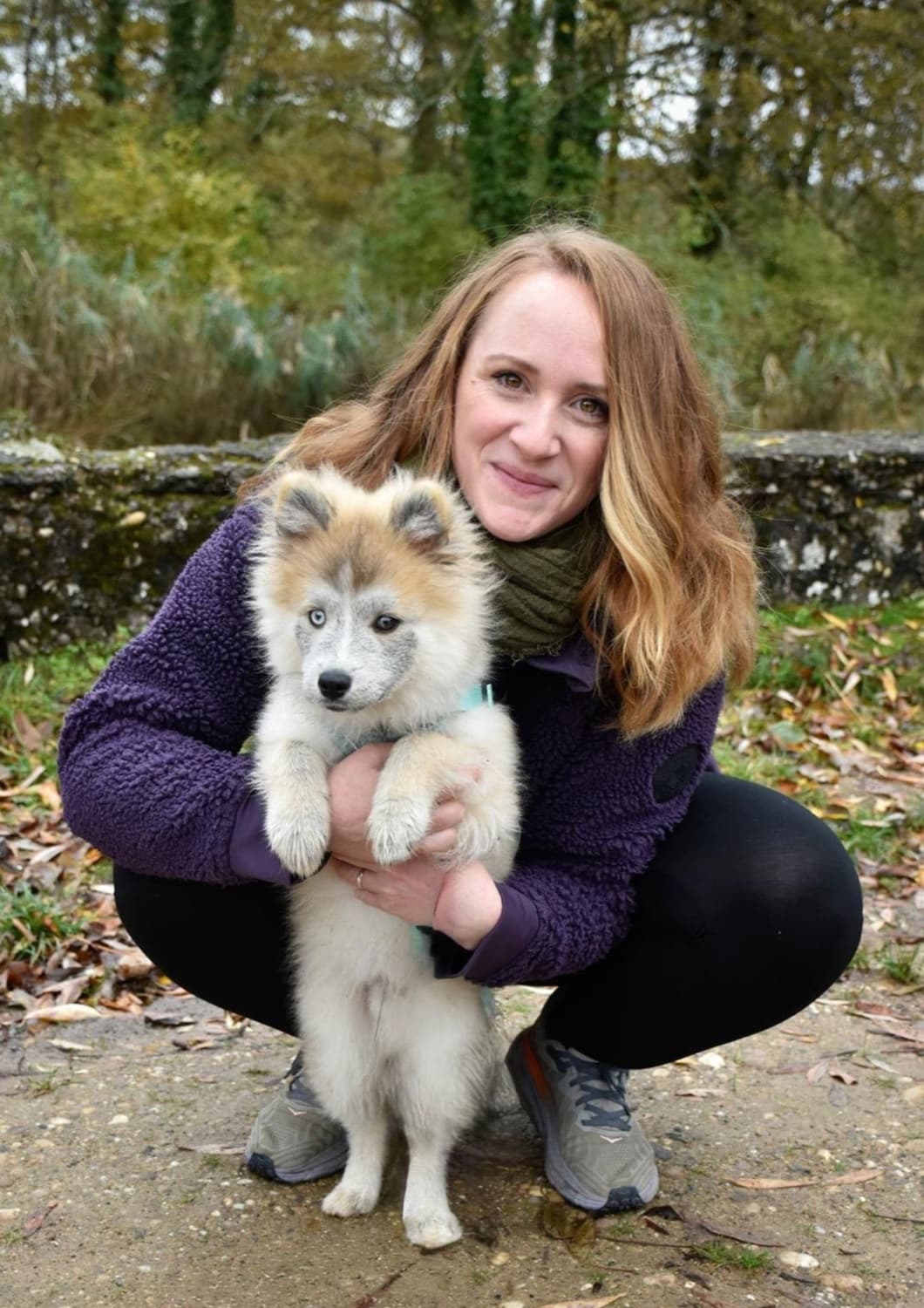 Priscilla, comportementaliste canine, avec un chiot dans les bras